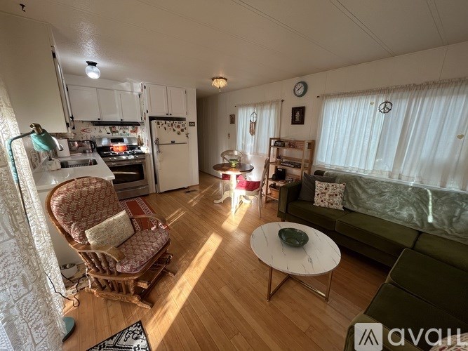 A living room with a green couch, a chair, and a coffee table.