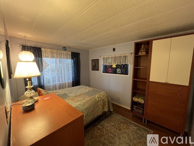 A bedroom with a bed, nightstand, and a lamp.