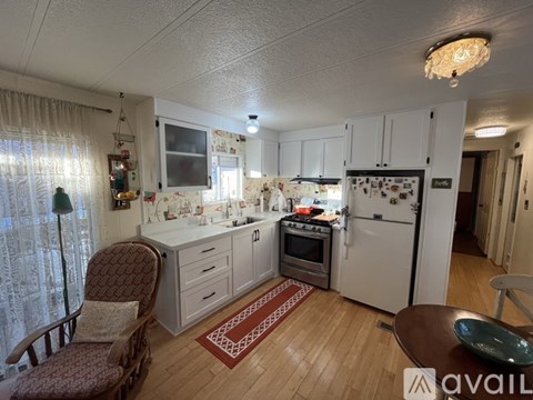 A kitchen with a refrigerator, oven, and sink.