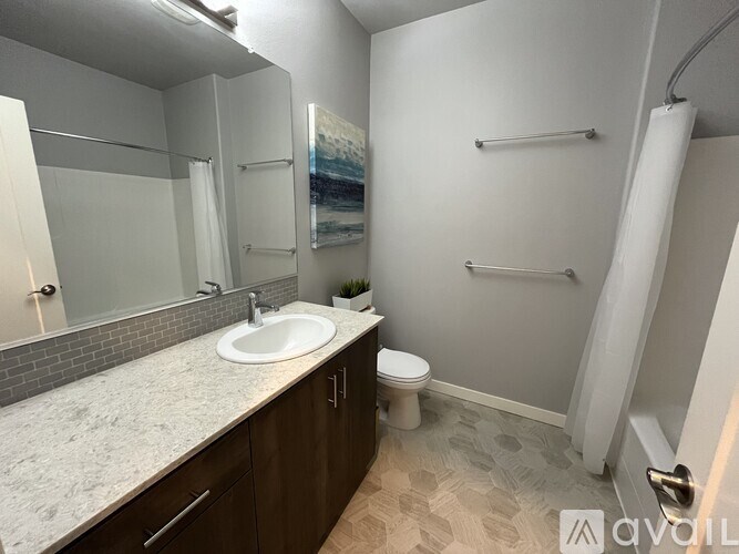 A bathroom with a sink, toilet, and a shower.