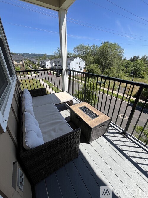 A balcony with a couch and a table with a fire pit on it.