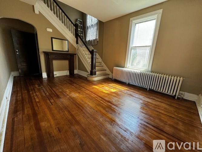 A room with wooden floors and a staircase.