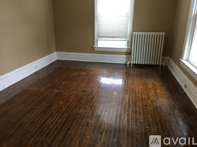 A room with wooden flooring and a white radiator.