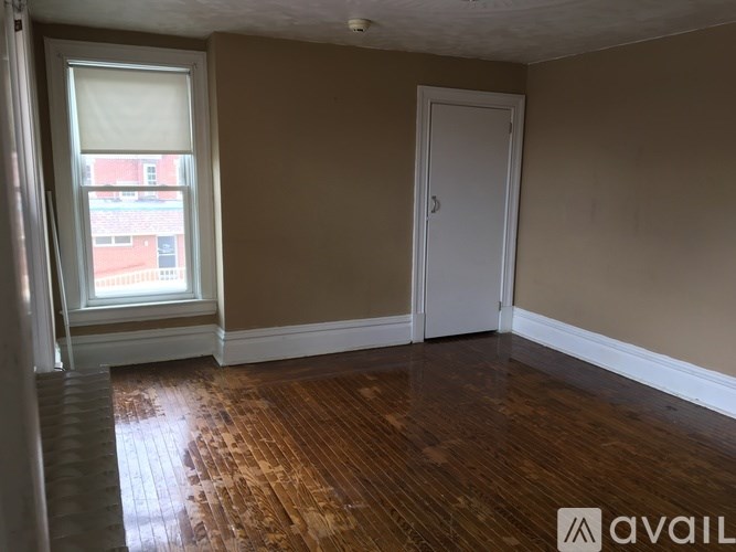 A room with a wooden floor and a white door.