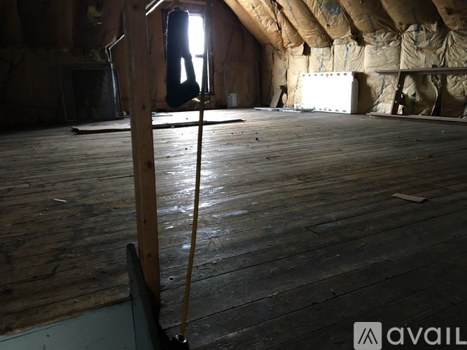 A room with wooden floors and a window in the background.