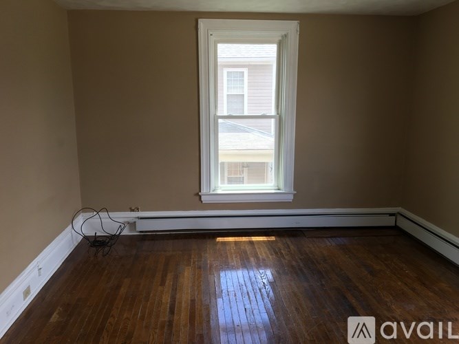 A room with a wooden floor and a window.
