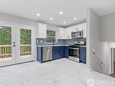 A kitchen with white cabinets and a blue island.