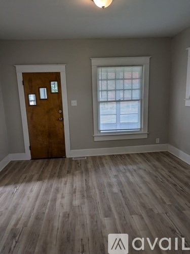 A room with a wooden door and a window with blinds.