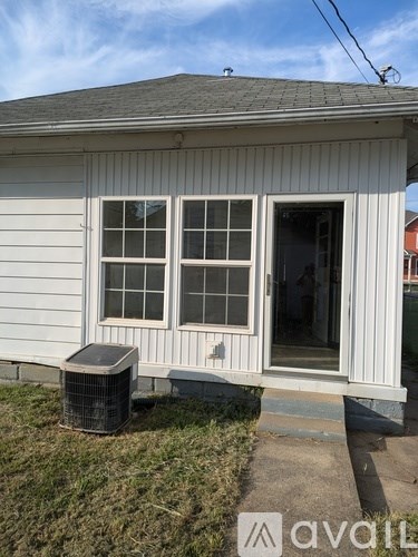 A white house with a window and a door is shown.