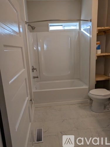 A bathroom with a toilet, tub, and shower.