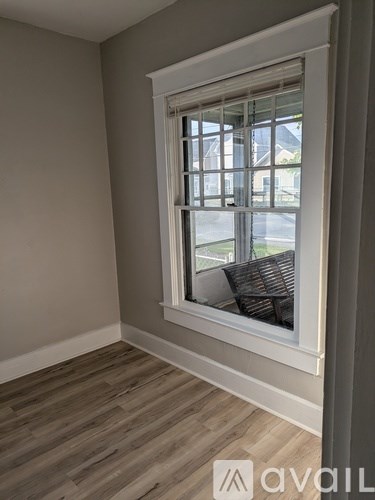 A room with a window and wooden flooring.