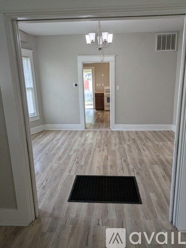 A room with a wooden floor and a chandelier.