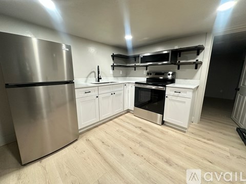 A kitchen with a stainless steel refrigerator and white cabinets.