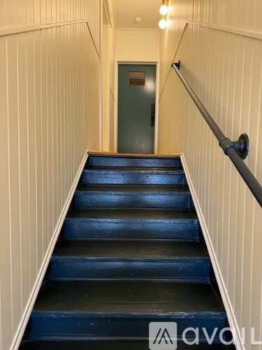 A staircase with a metal handrail and wooden steps.