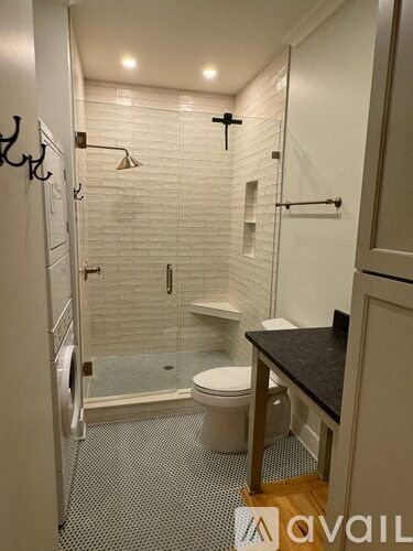 A bathroom with a toilet, sink, and shower.