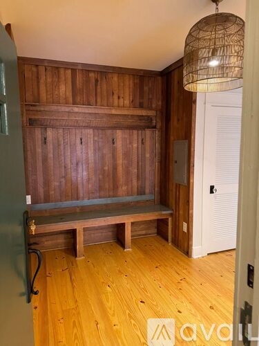 A wooden bench sits in front of a wooden wall.