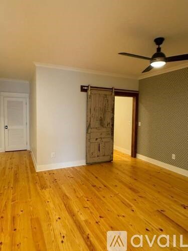 A room with wooden floors and a ceiling fan.