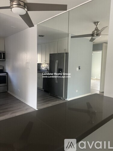 A modern kitchen with a glass countertop and a ceiling fan.