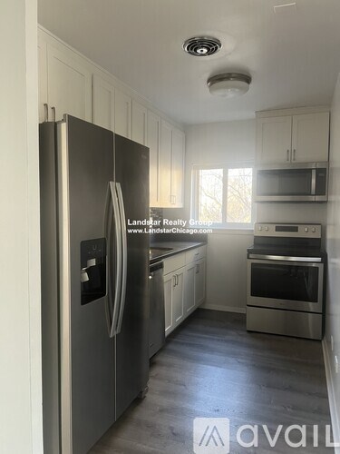 A kitchen with a stainless steel refrigerator and a stove.