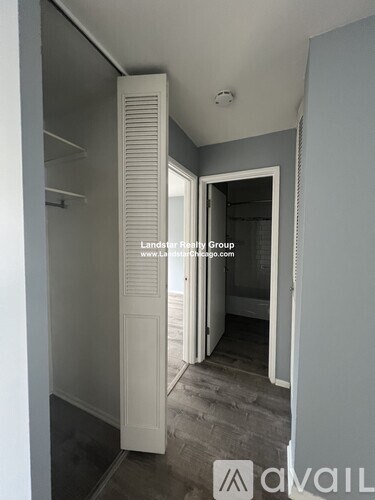 A hallway with a door open to a bathroom.