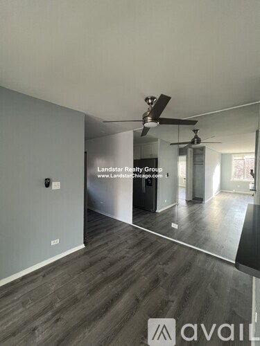 A room with a fan and a website address on the wall.