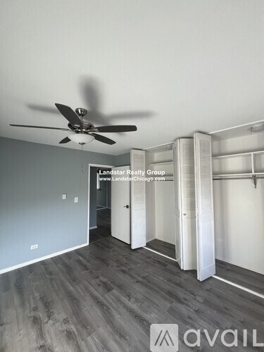 A room with a fan and a wall with a sign that says "Landstar Realty Group".