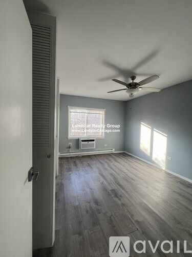 A room with a fan and a window with blinds.
