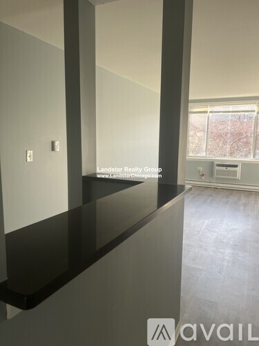 A room with a black countertop and a window with a view of trees outside.