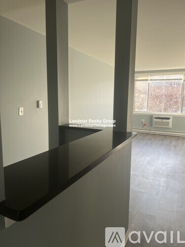 A room with a black countertop and a window with a view of trees outside.
