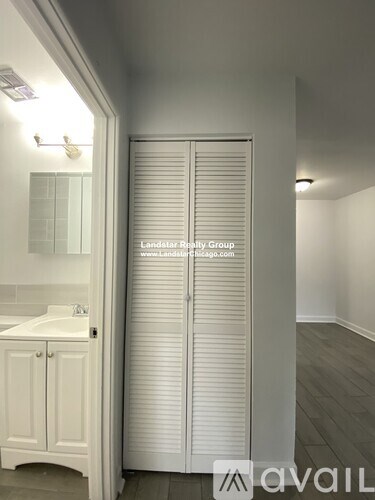A white bathroom with a sink and a white cabinet.