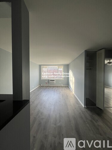 A room with a wooden floor and a large window.