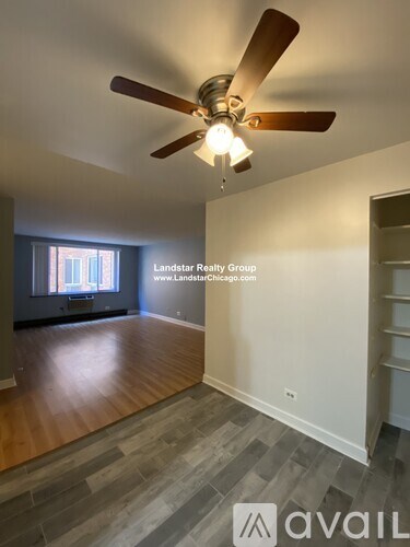 A room with a ceiling fan and wooden flooring.