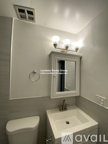 A white toilet sits next to a sink in a small bathroom.