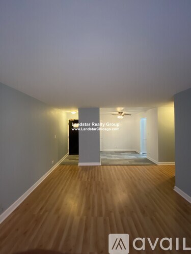 A room with wooden flooring and a sign for "Landstar Realty Group" is shown.