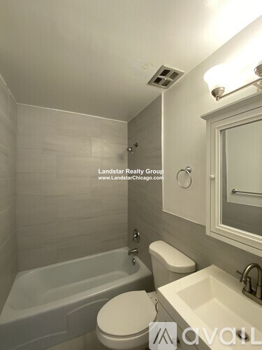 A white toilet sits next to a bathtub in a bathroom.