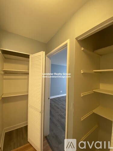 A white closet with shelves and an open door.
