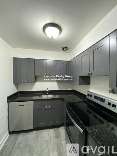 A kitchen with a black counter top and a stove top oven.