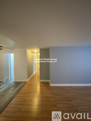 A long hallway with wooden floors and white walls.