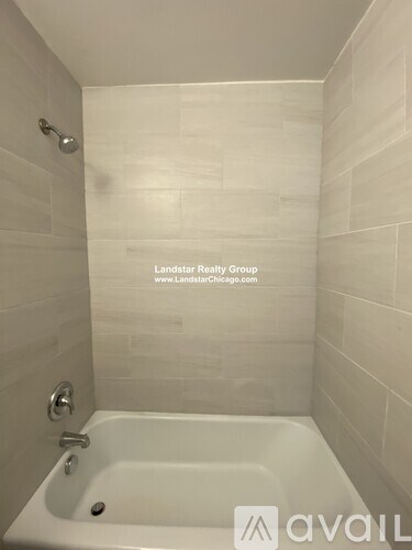 A white bathtub in a bathroom with Landstar Realty Group logo.