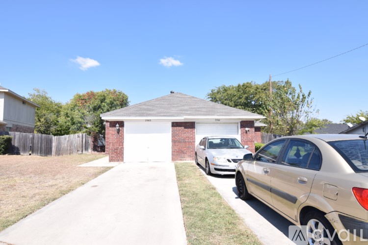 A house with a garage and a car parked in front.