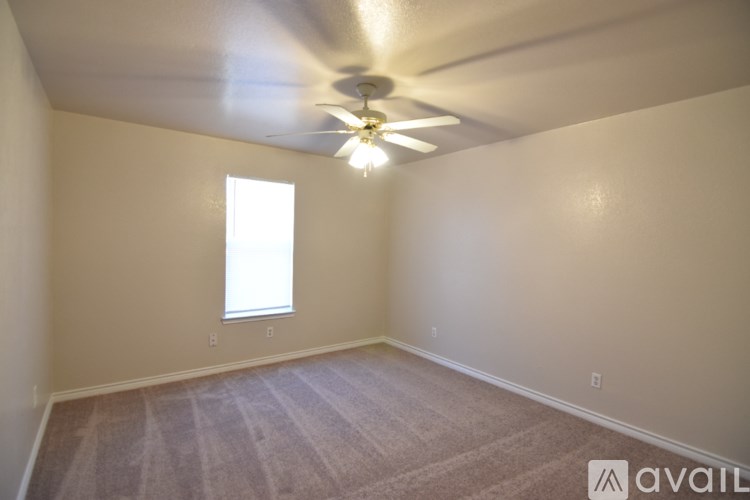 A room with a ceiling fan and a window.