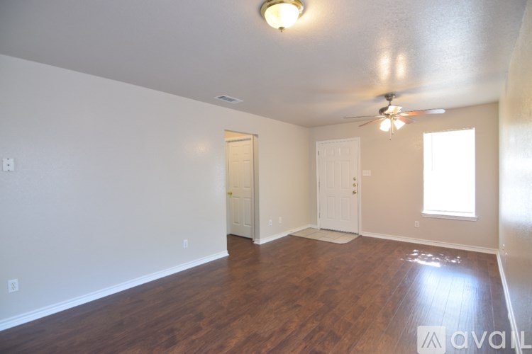 A room with wooden floors and a ceiling fan.