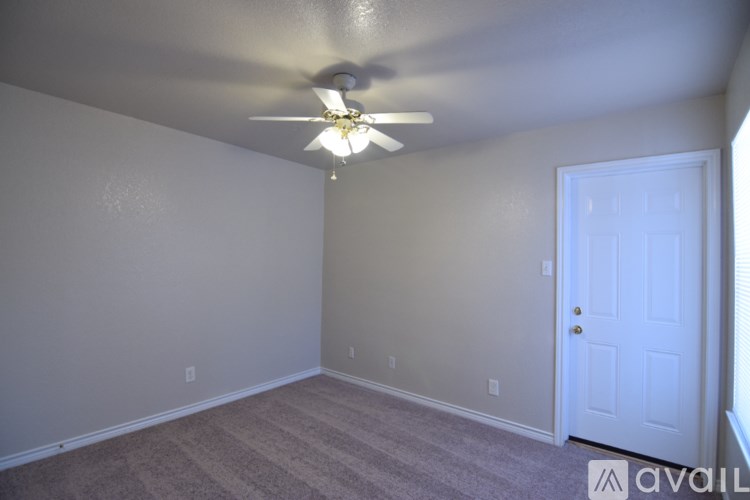 A room with a ceiling fan and a door.