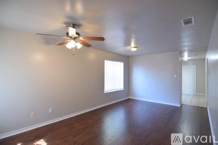 A room with a ceiling fan and wooden floors.
