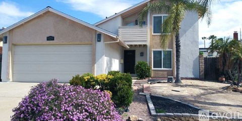 A house with a white garage door and a palm tree in front.
