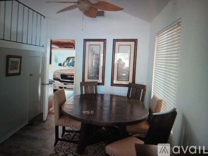 A dining room with a table and chairs.