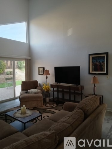 A living room with a couch, chair, and television.