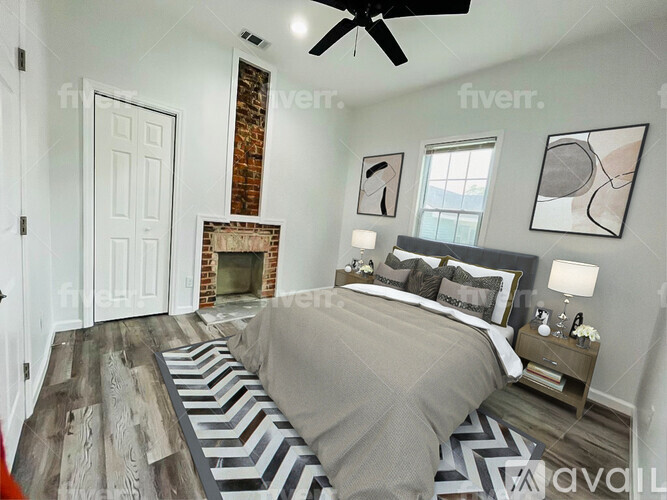 A bedroom with a large bed and a fireplace.