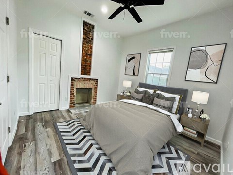 A bedroom with a large bed and a fireplace.
