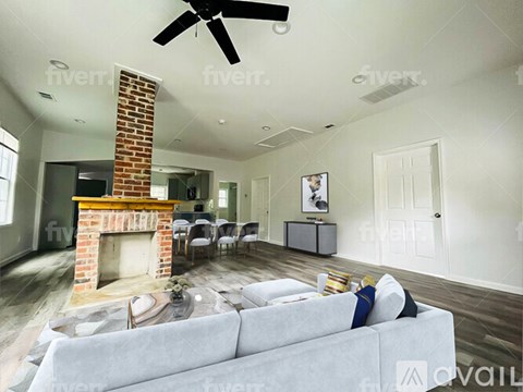 A living room with a grey couch and a fireplace.